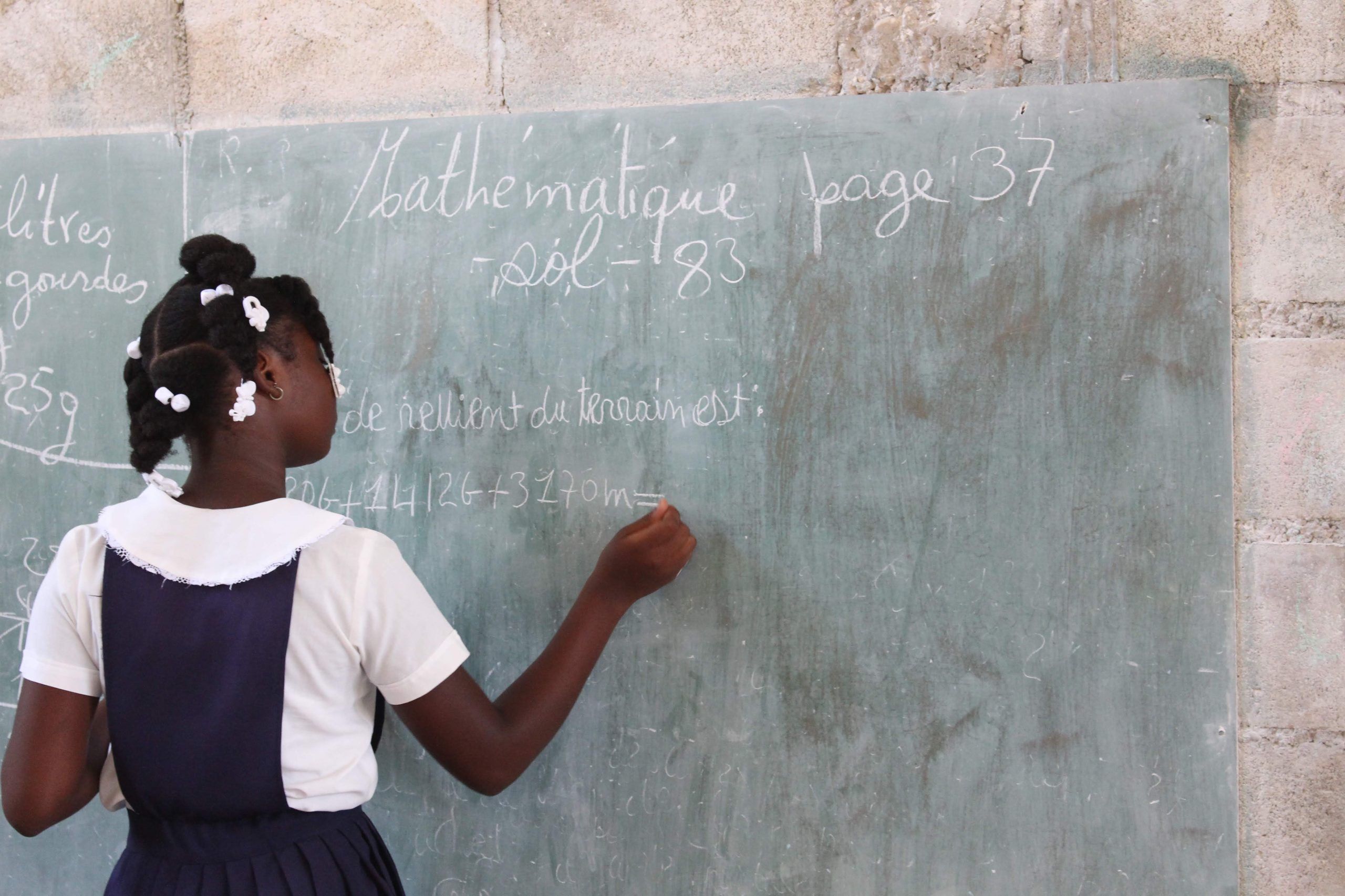 School student working on a chalkboard