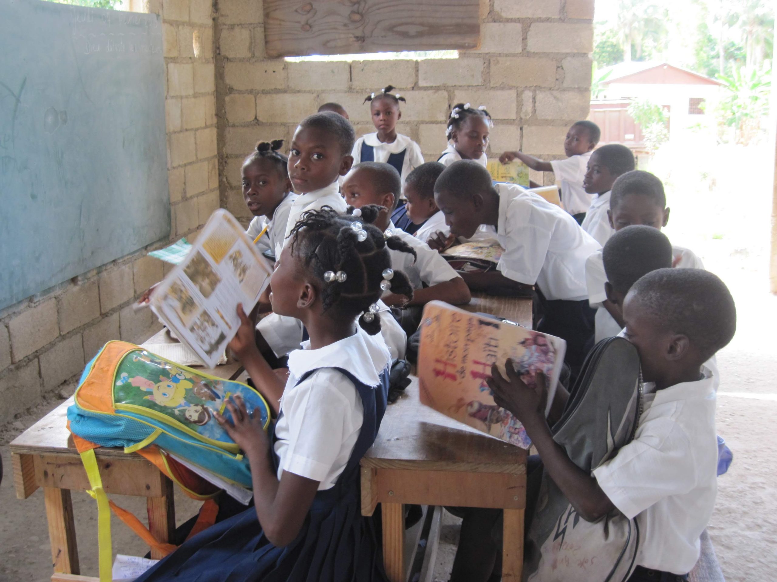 Seating school children facing chalkboard
