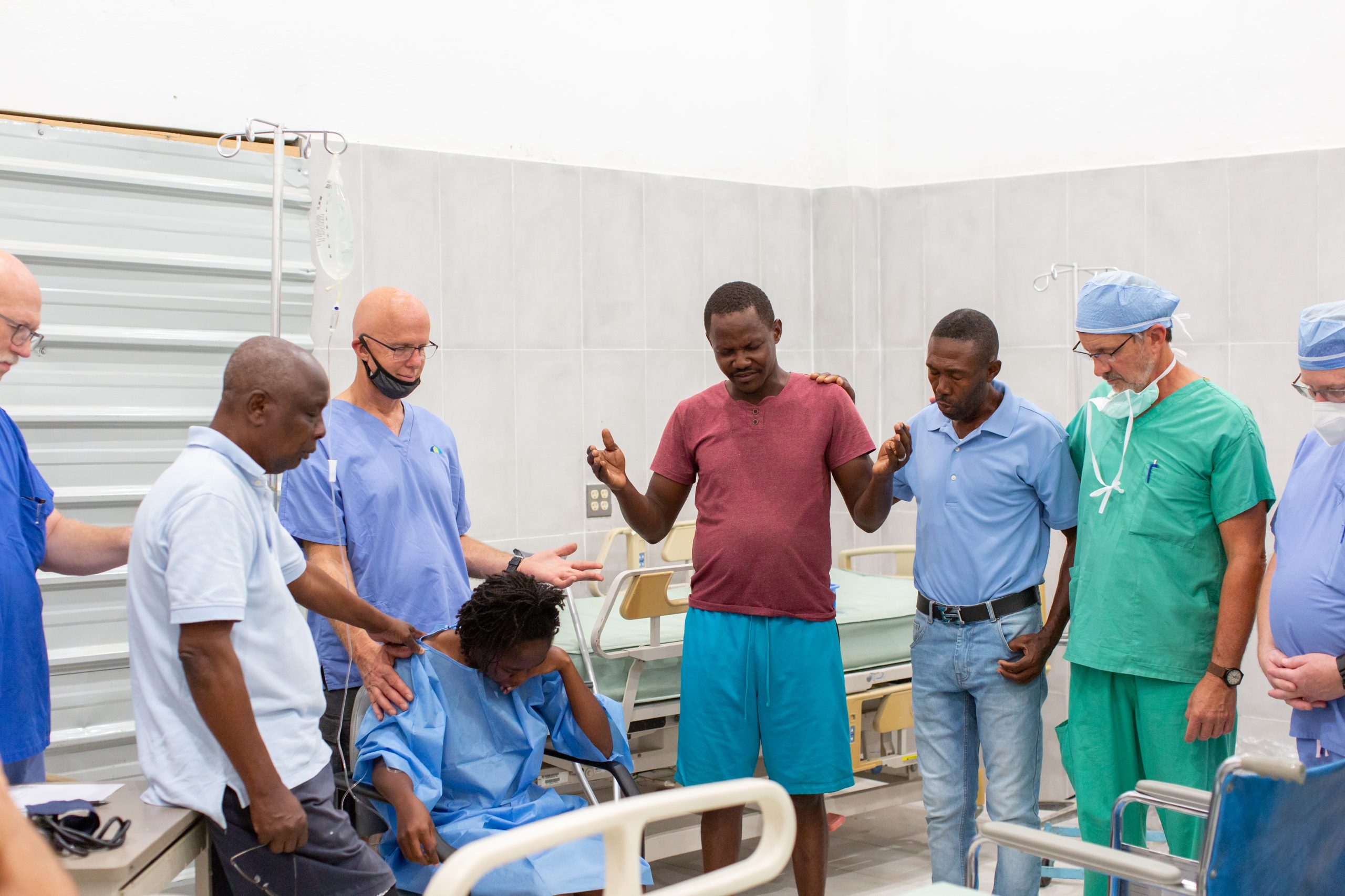 A group of people praying over a patient